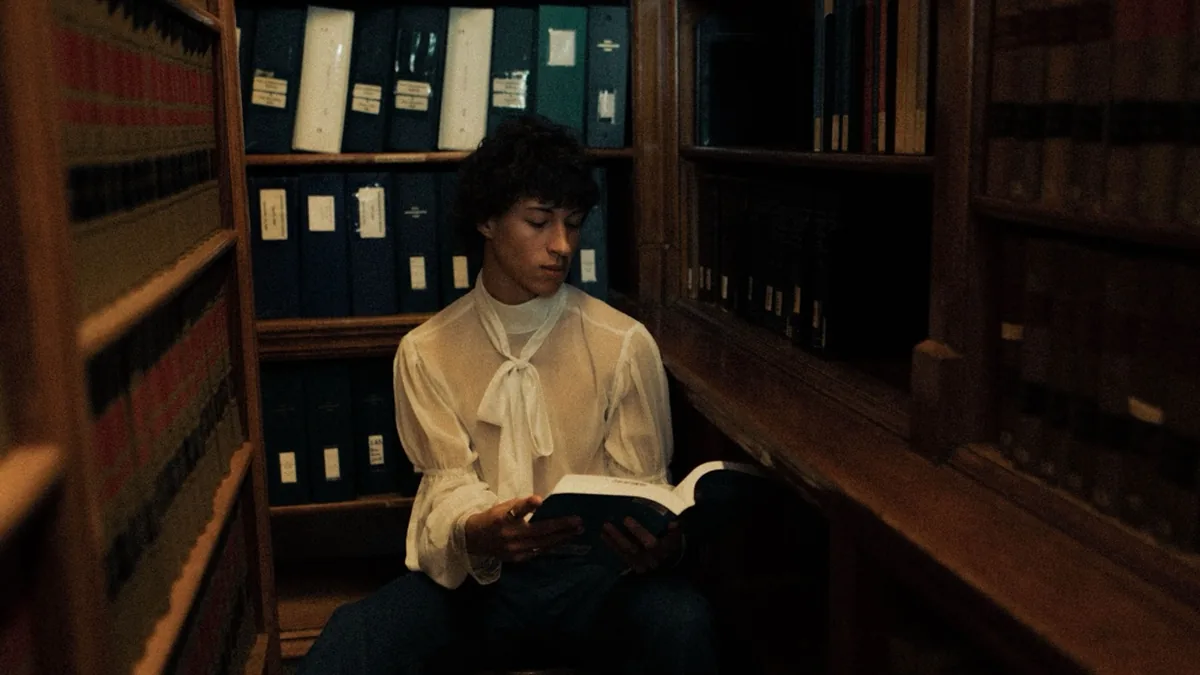 Jongen leest in een stille bibliotheek; centraal redactioneel beeld voor de vakpagina.