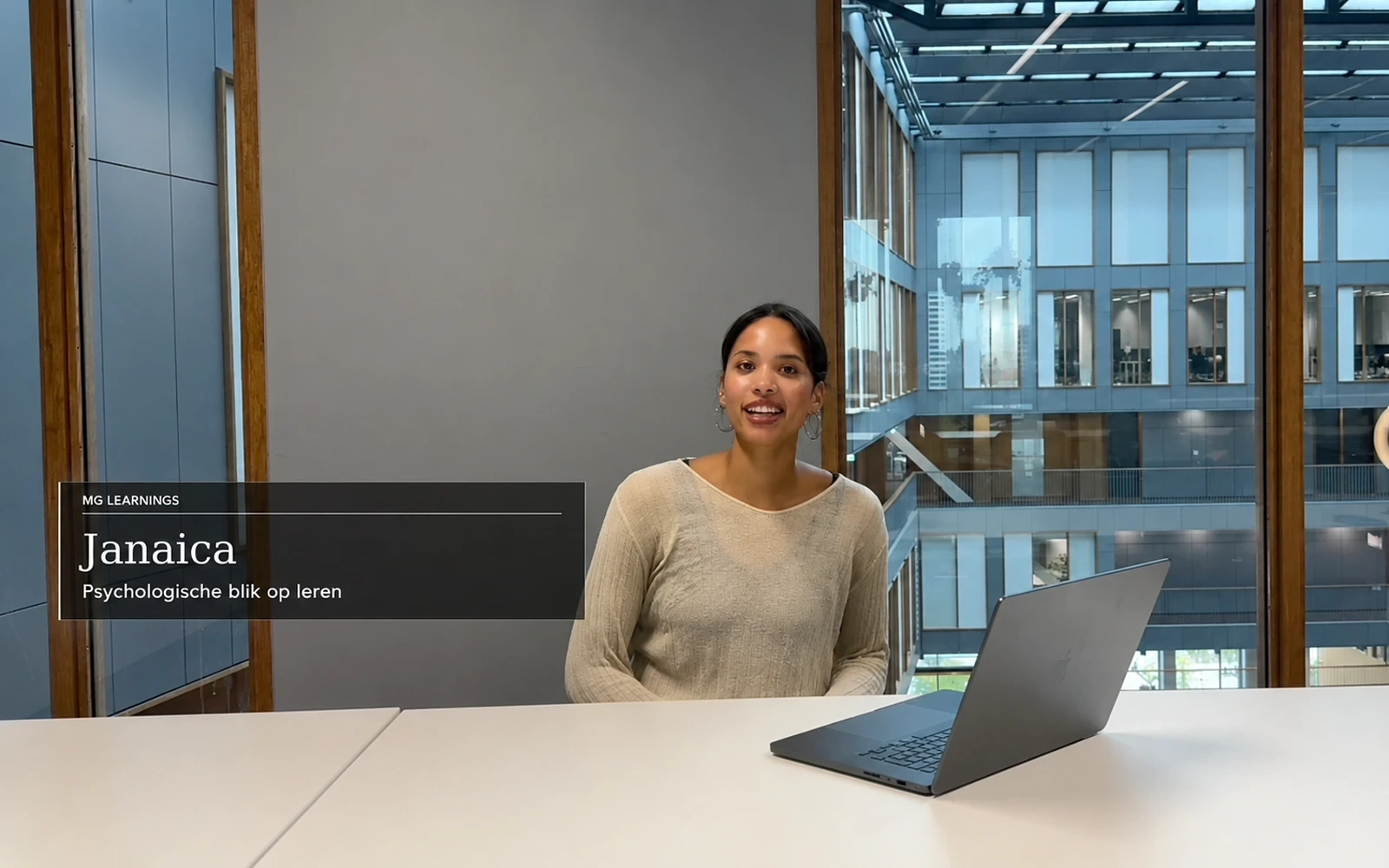 Janaica, met een psychologische blik op leren, zittend aan tafel met een laptop.